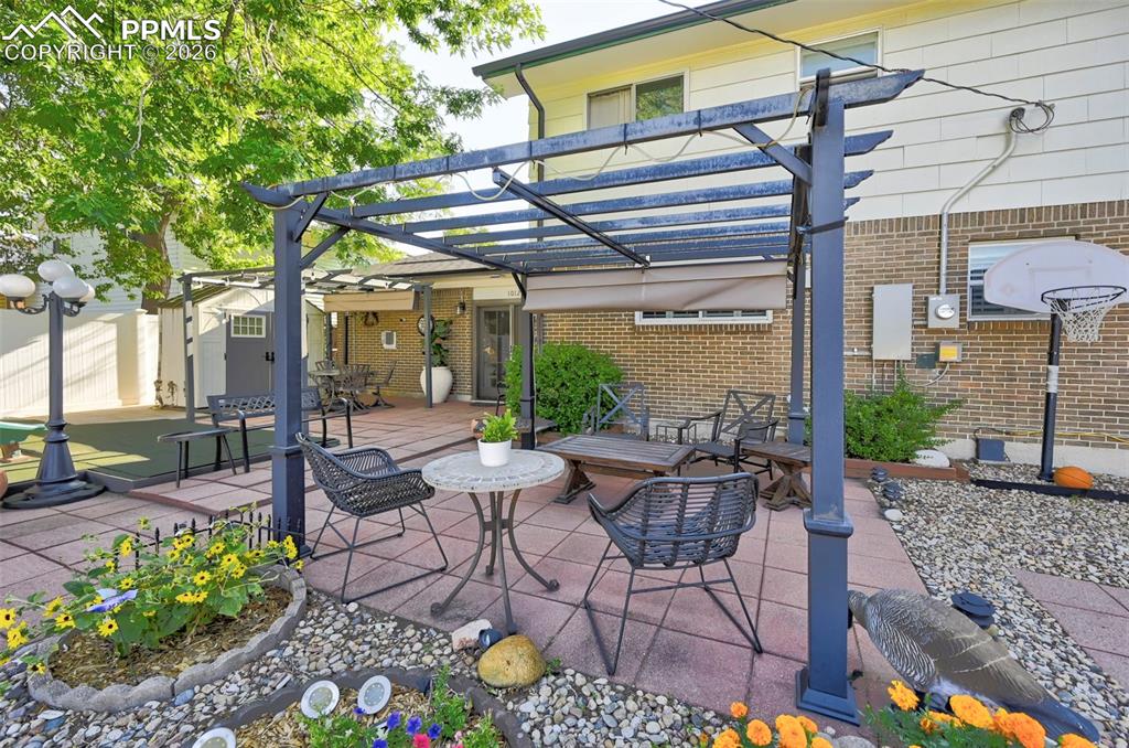 Image 12 of 46: View of patio / terrace featuring a pergola and outdoor dining area