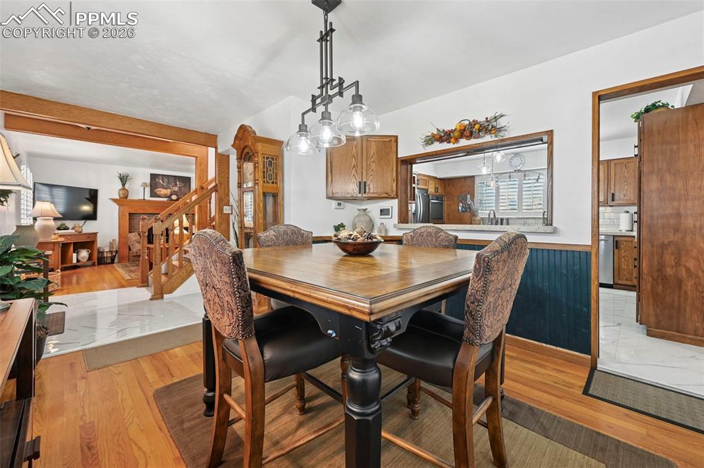 Image 25 of 46: Dining room with light wood-type flooring and wainscoting