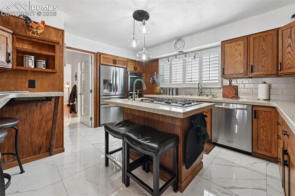 Image 26 of 46: Kitchen featuring a breakfast bar area, wood finish cabinetry, stainless st
