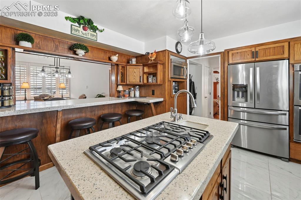 Image 27 of 46: Kitchen featuring stainless steel appliances, wood finish cabinetry, a kitc