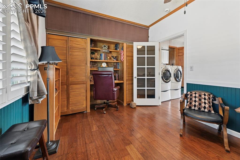 Image 33 of 46: Home office with wainscoting, wooden walls, dark wood finished floors, wash