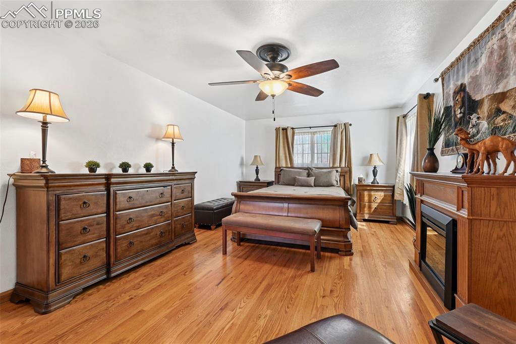 Image 35 of 46: Bedroom featuring a ceiling fan, light wood-style flooring, and a glass cov