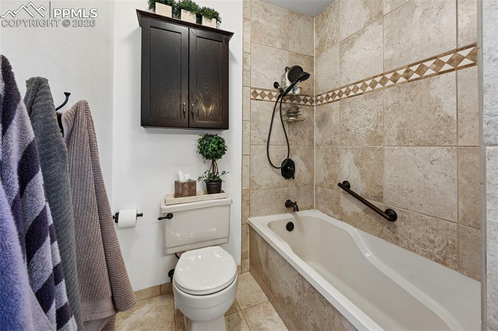 Image 39 of 46: Full bath with tiled shower / bath combo and light tile patterned flooring