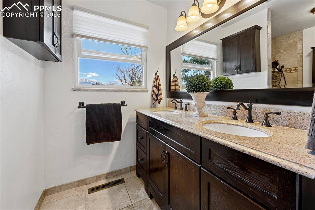 Image 40 of 46: Full bath featuring double vanity and light tile patterned floors