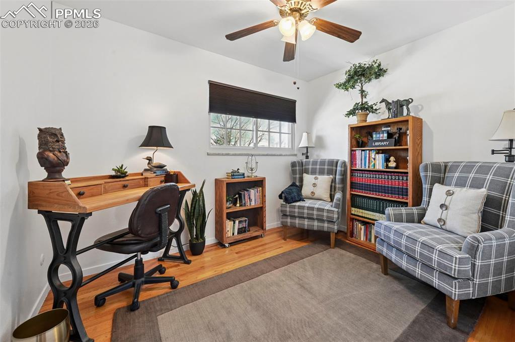 Image 45 of 46: Office with wood finished floors and ceiling fan