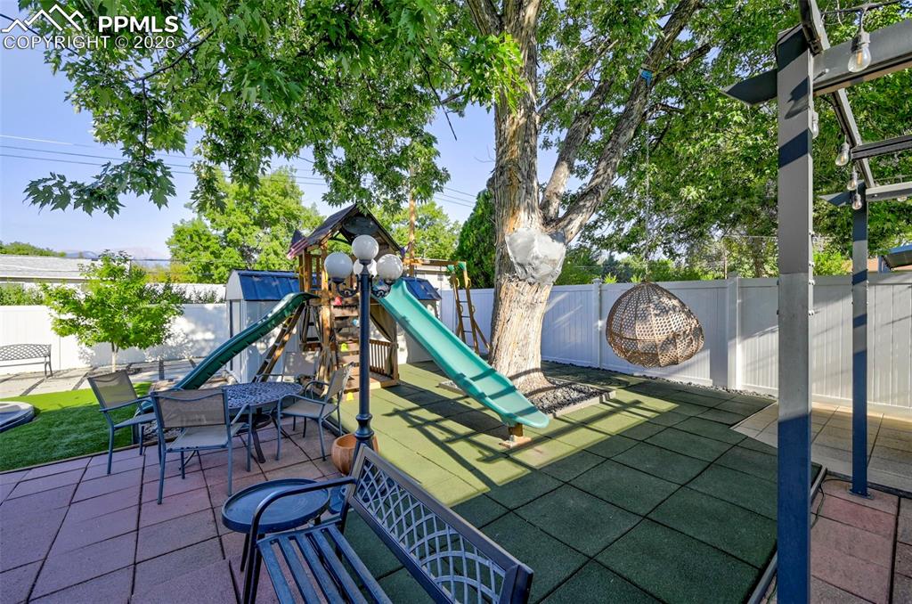 Image 5 of 46: View of jungle gym featuring a fenced backyard and a patio