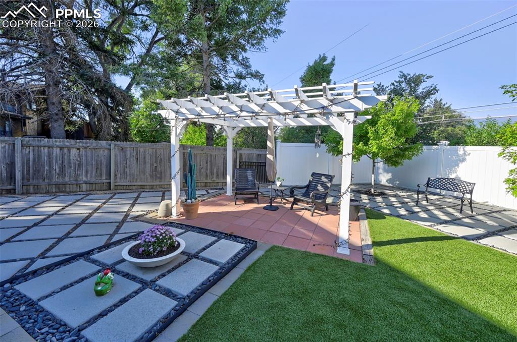 Image 8 of 46: Fenced backyard featuring a pergola and a patio