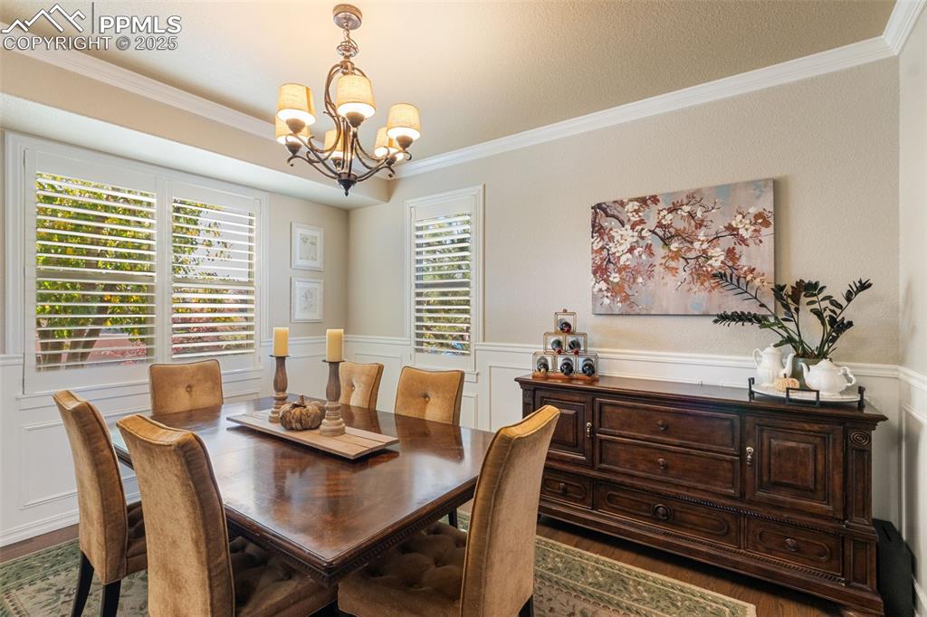 Image 14 of 46: Dining space featuring ornamental molding, dark wood finished floors, a dec