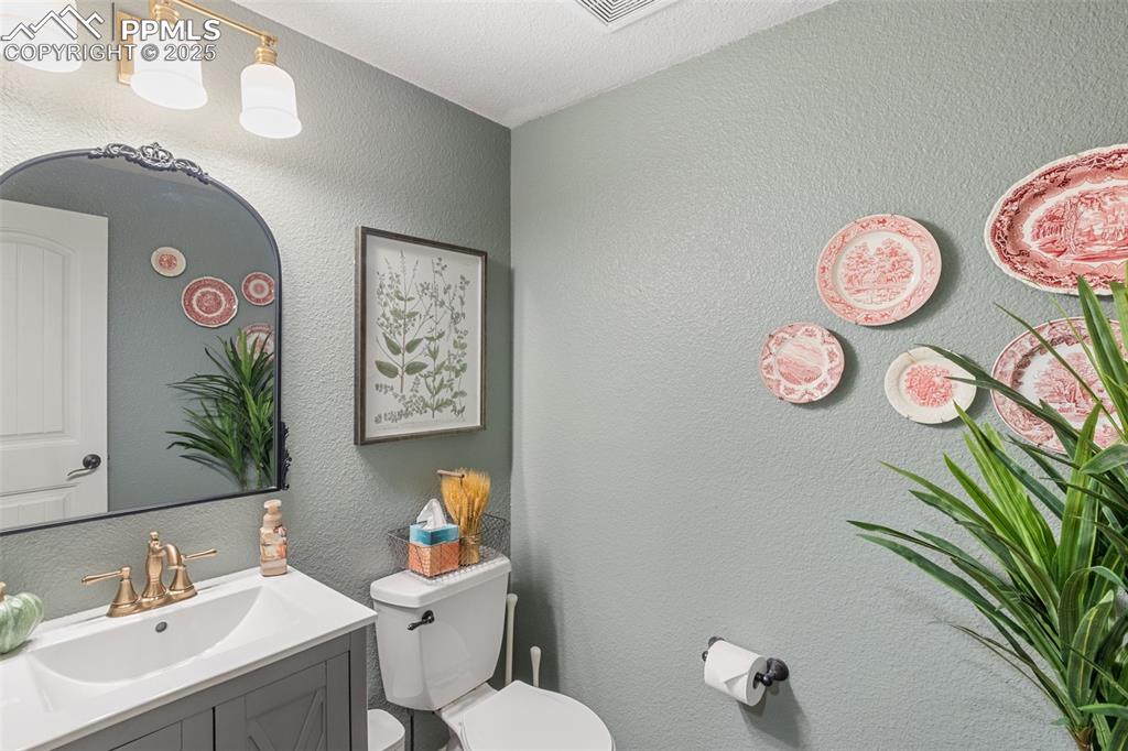 Image 18 of 46: Half bath with a textured wall and vanity