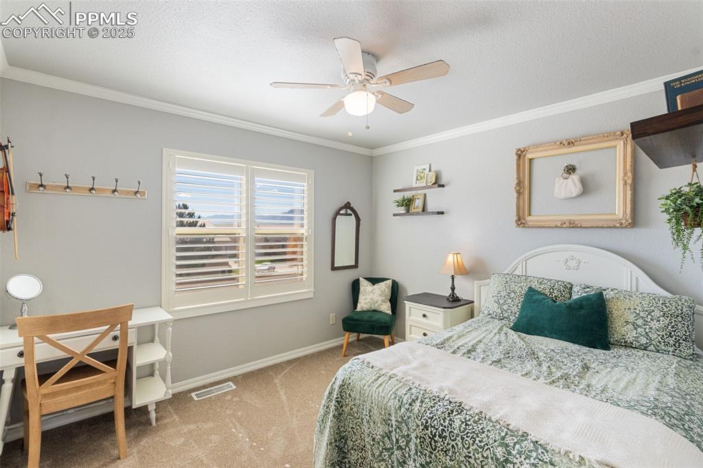 Image 22 of 46: Bedroom featuring carpet, ornamental molding, a textured ceiling, and ceili
