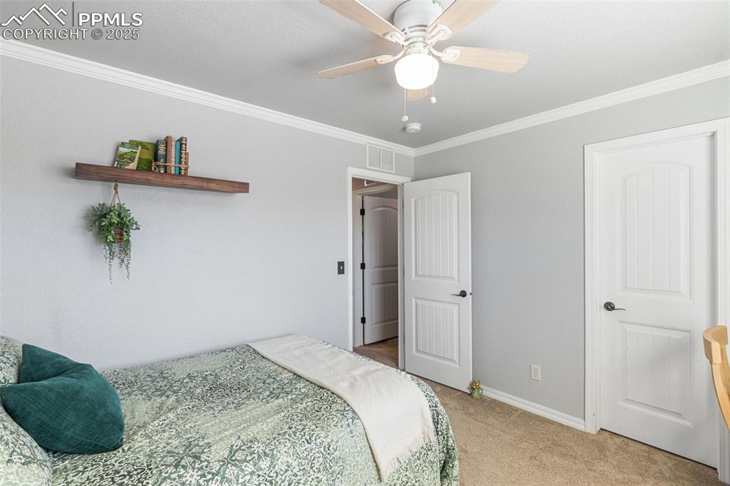 Image 23 of 46: Bedroom featuring light carpet, ornamental molding, and ceiling fan