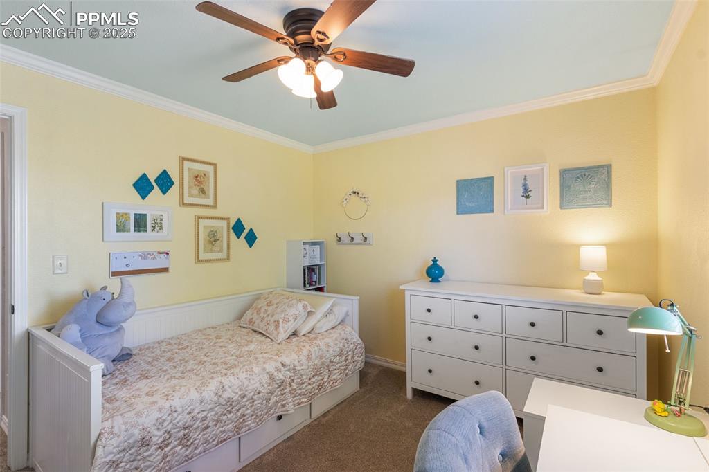 Image 25 of 46: Bedroom featuring crown molding, dark carpet, and ceiling fan