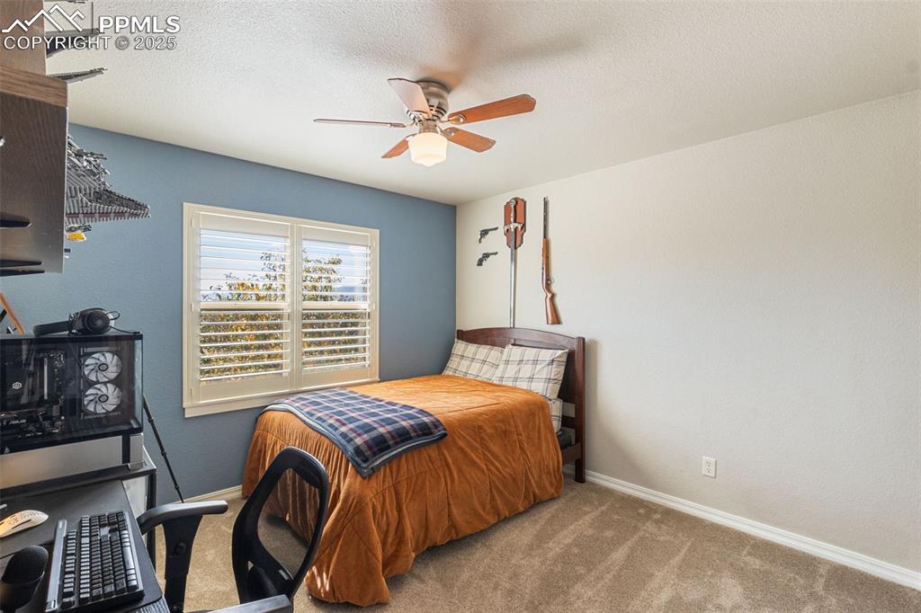 Image 27 of 46: Carpeted bedroom featuring a textured ceiling, a ceiling fan, and a texture