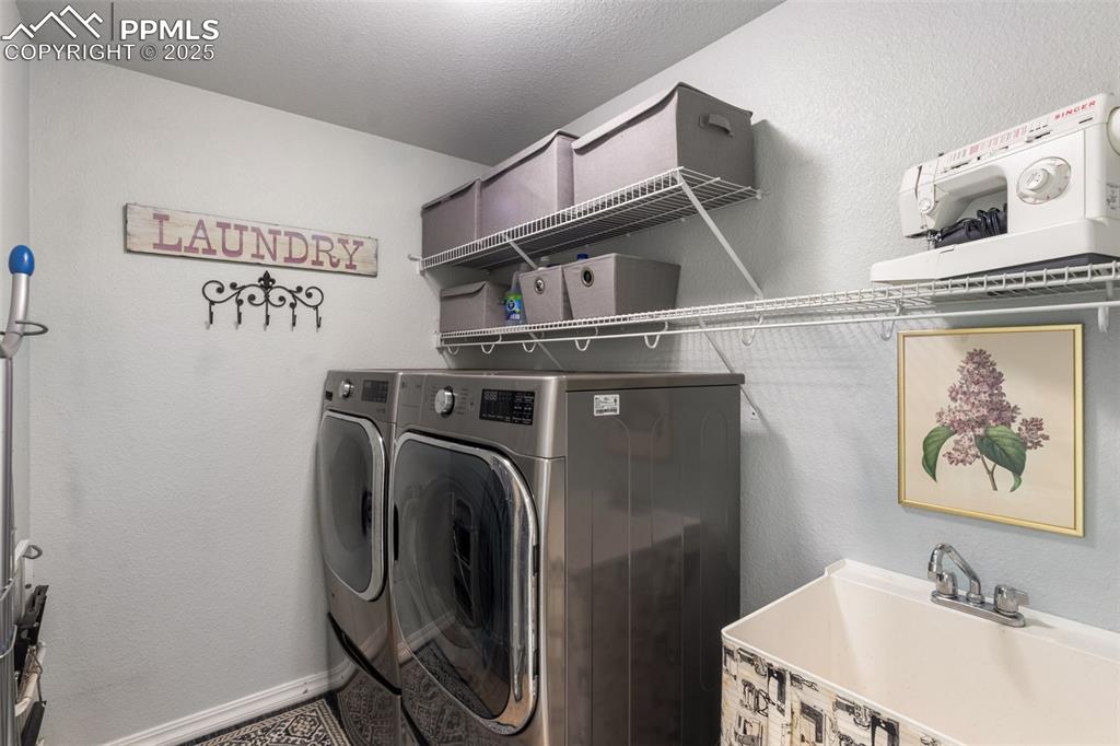 Image 28 of 46: Laundry area with a textured wall, washer and clothes dryer, and a textured