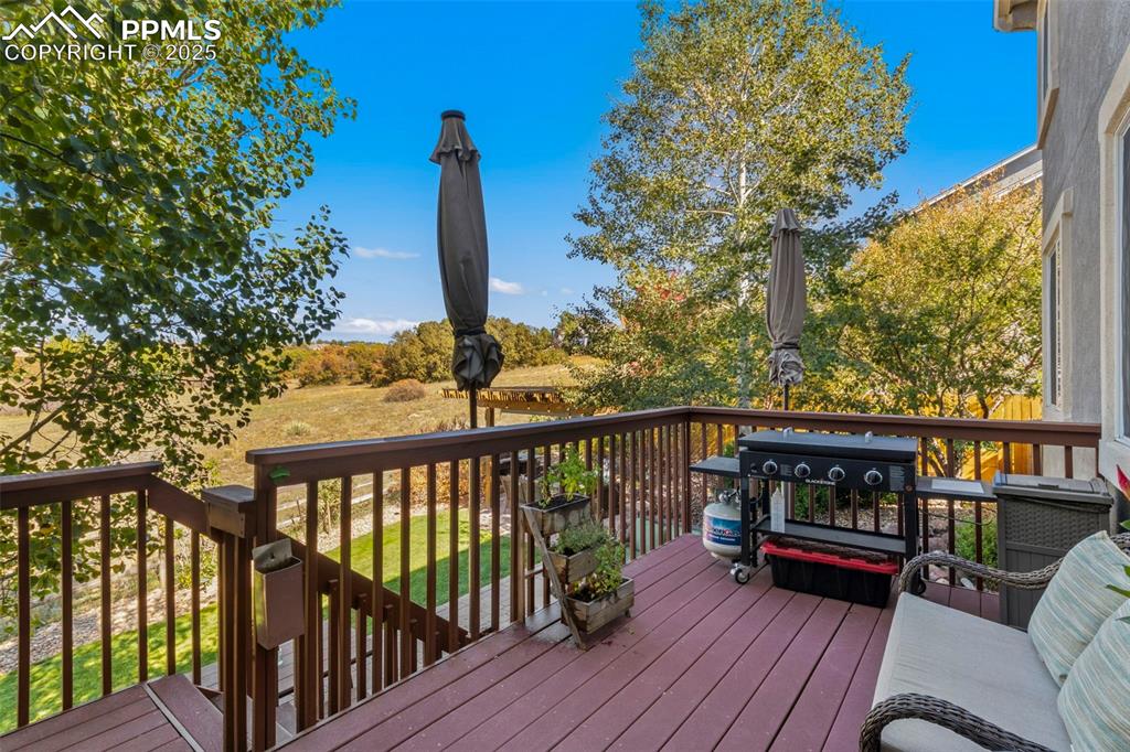 Image 4 of 46: Wooden deck with a grill and view of open space