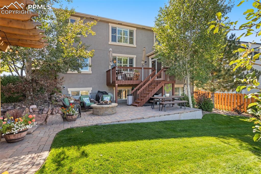 Image 41 of 46: Back of house featuring stucco siding, a patio area, a fire pit, and stairs