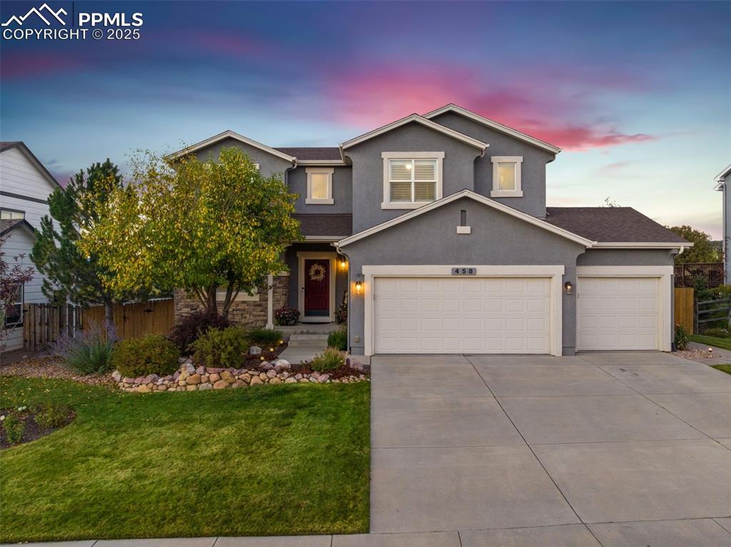 Image 43 of 46: Traditional-style home featuring stucco siding, driveway, a garage, and sto