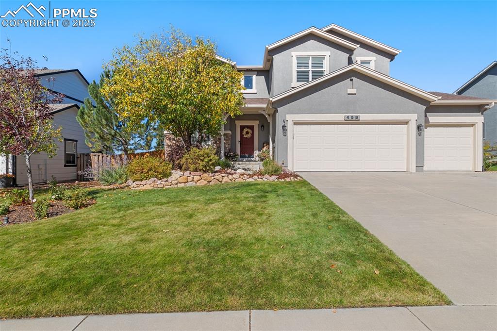 Image 46 of 46: View of front of property featuring stucco siding, a garage, and concrete d