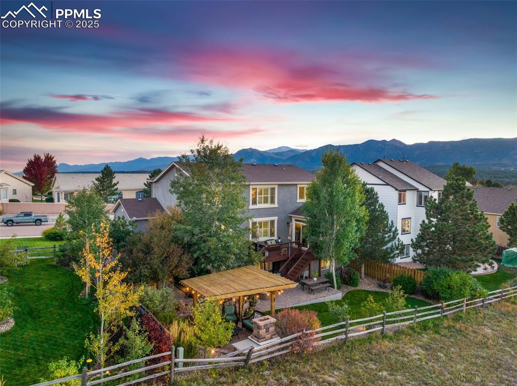 Image 5 of 46: Back of property featuring a fenced backyard, an outdoor fire pit, and a de