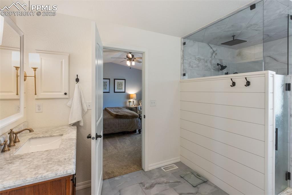 Image 7 of 46: Full bathroom with walk in shower, vanity, ensuite bathroom, ceiling fan, a