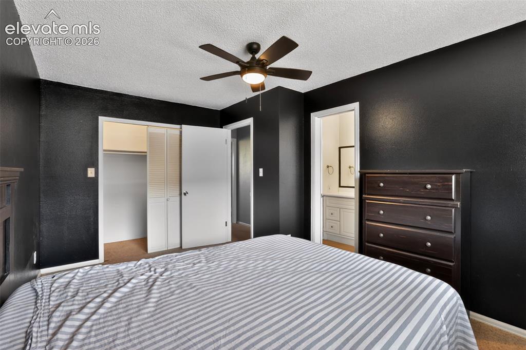 Image 14 of 28: Bedroom featuring dark accent walls, ceiling fan with integrated lighting, 