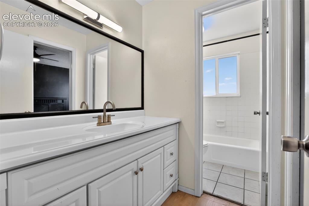 Image 16 of 28: Bathroom vanity featuring a white cabinetry, integrated sink, and brushed n