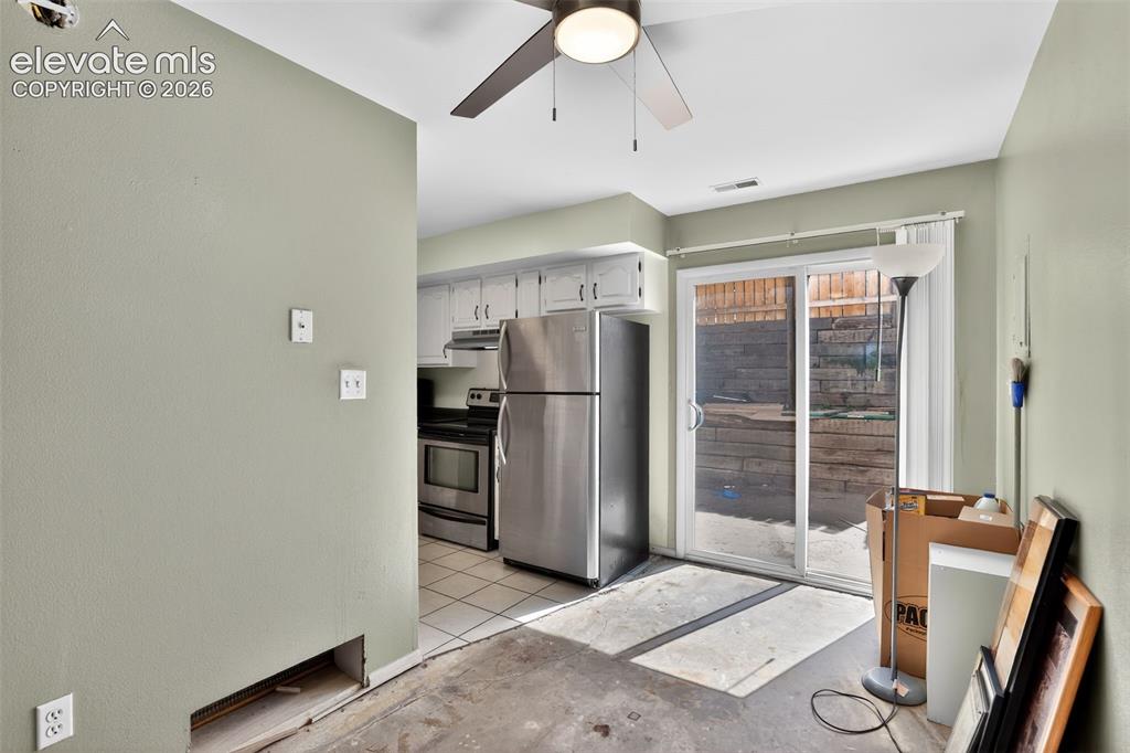 Image 7 of 28: Kitchen area featuring white cabinetry and stainless steel appliances