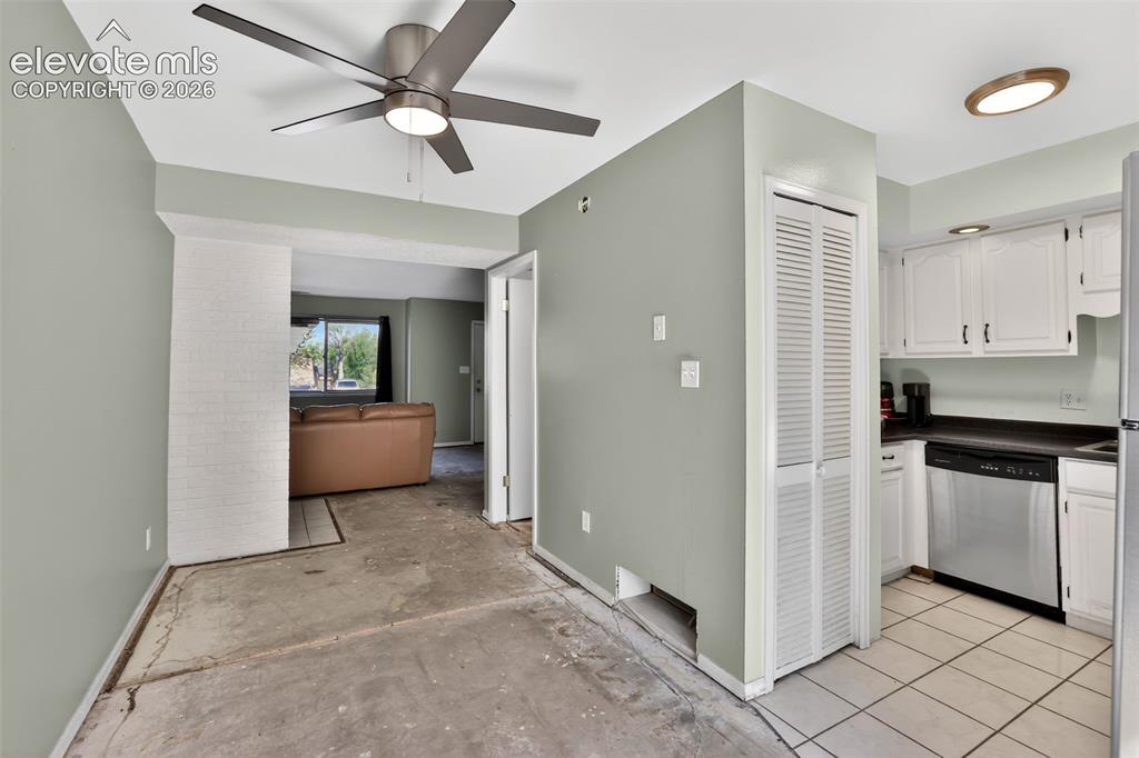 Image 8 of 28: Kitchen area featuring white cabinetry, dark countertops, and stainless ste