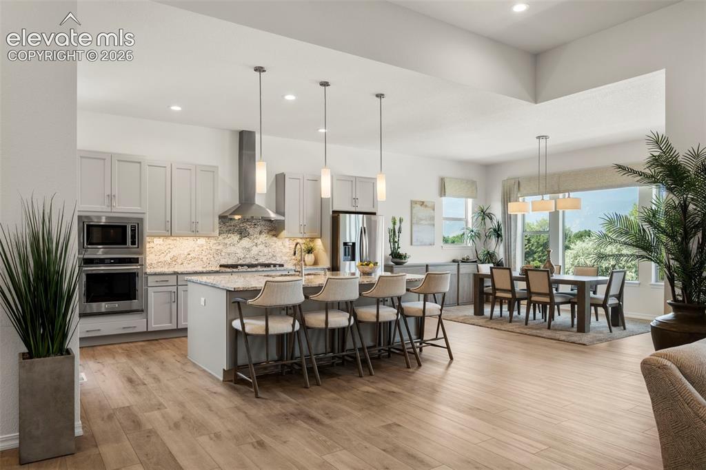 Image 12 of 50: Kitchen featuring light custom cabinetry, stainless steel appliances, grani
