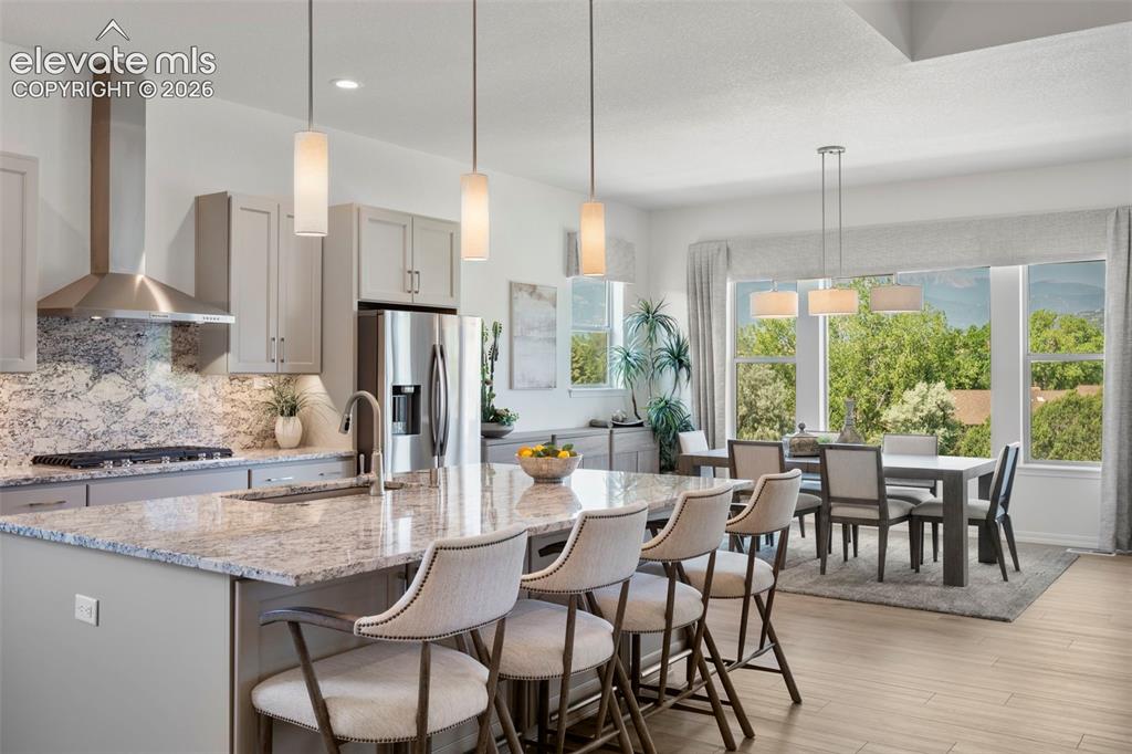 Image 13 of 50: Kitchen island with integrated sink, stainless steel appliances, stone coun