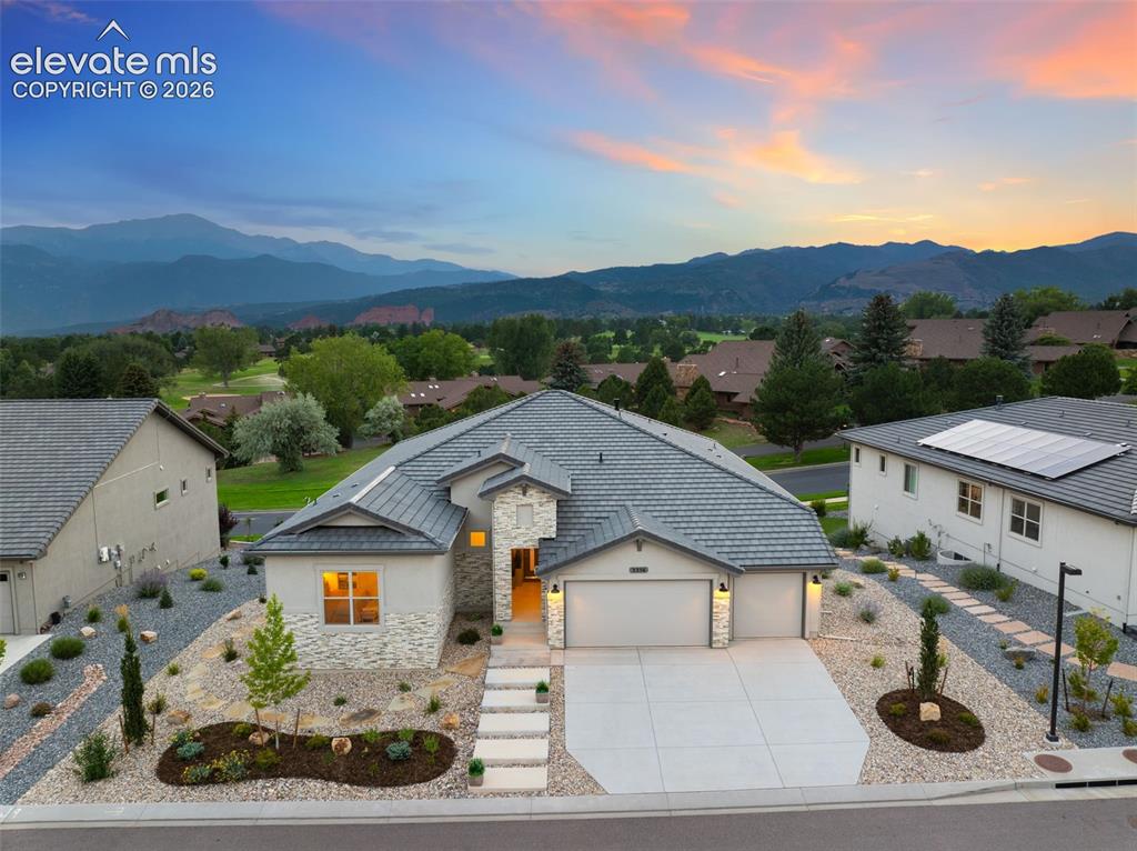 Image 2 of 50: Stucco exterior with stone accents, a multi-pane garage door, and a concret