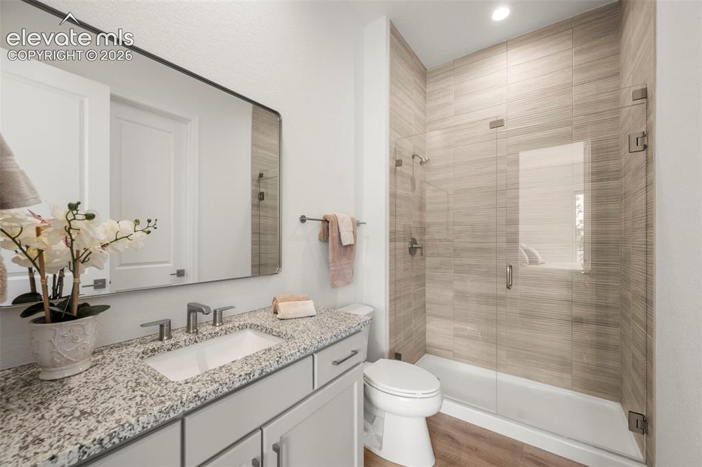 Image 25 of 50: Beautiful vanity with a granite countertop, undermount sink, walk-in shower
