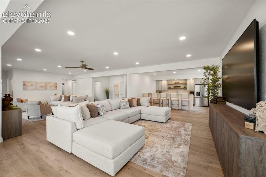 Image 29 of 50: Open-concept living area featuring wood-finish flooring, recessed lighting,