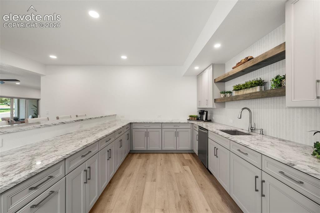 Image 33 of 50: Extensive counter space with light-toned cabinetry, recessed lighting, wood
