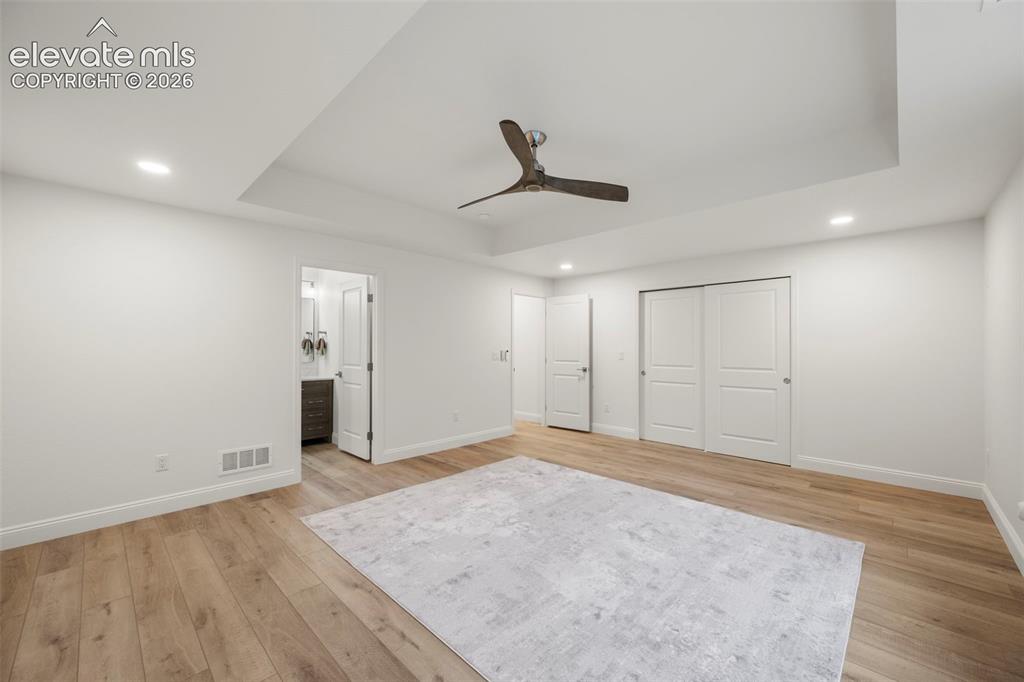 Image 35 of 50: Tray ceiling with recessed lighting and ceiling fan