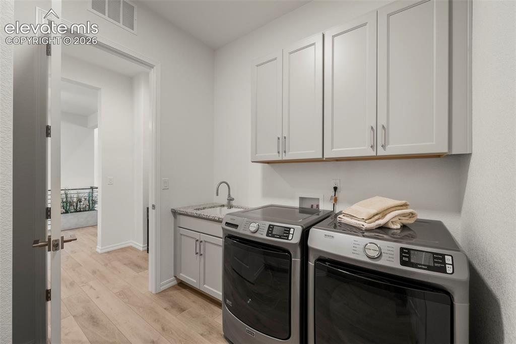 Image 39 of 50: Main level laundry attached to primary bedrooms walk-in closet. For added