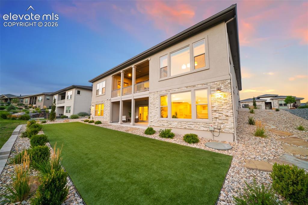 Image 44 of 50: Multi-level exterior with stucco and stone cladding