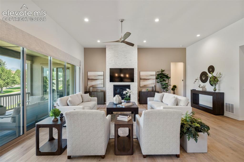 Image 9 of 50: Spacious living area featuring beautiful flooring, a contemporary fireplace