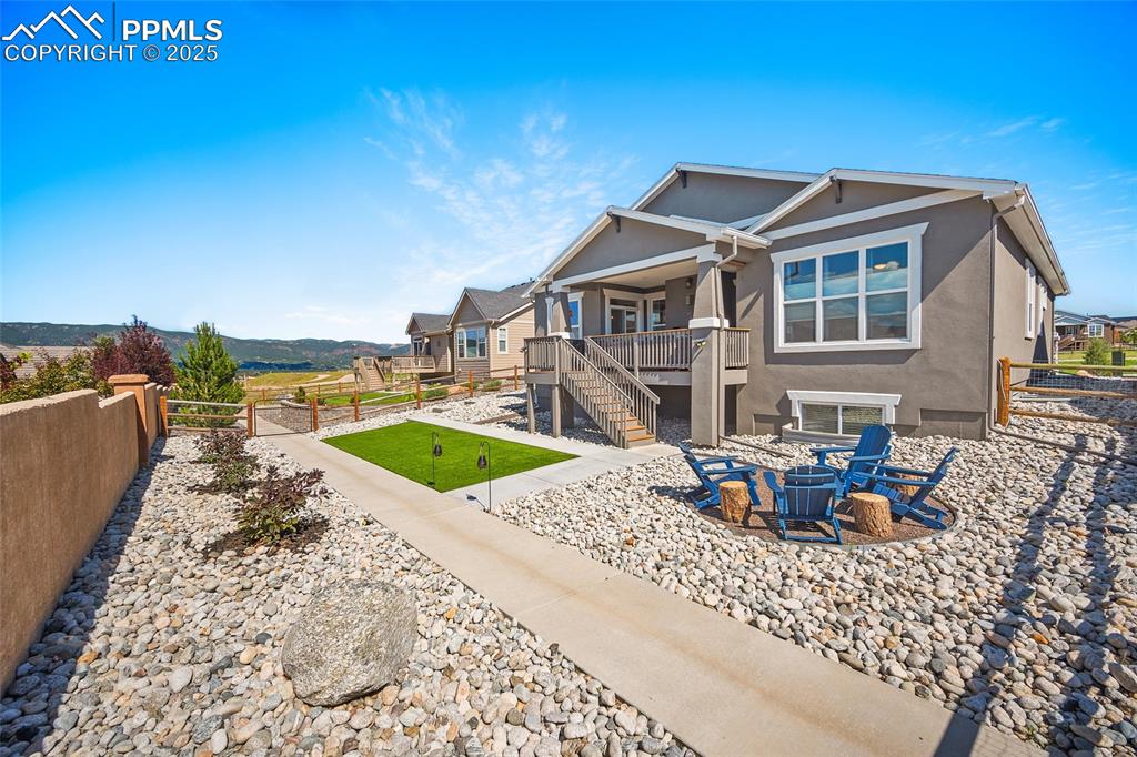 Image 18 of 41: Rear view of property featuring a fenced backyard, stucco siding, stairs, a