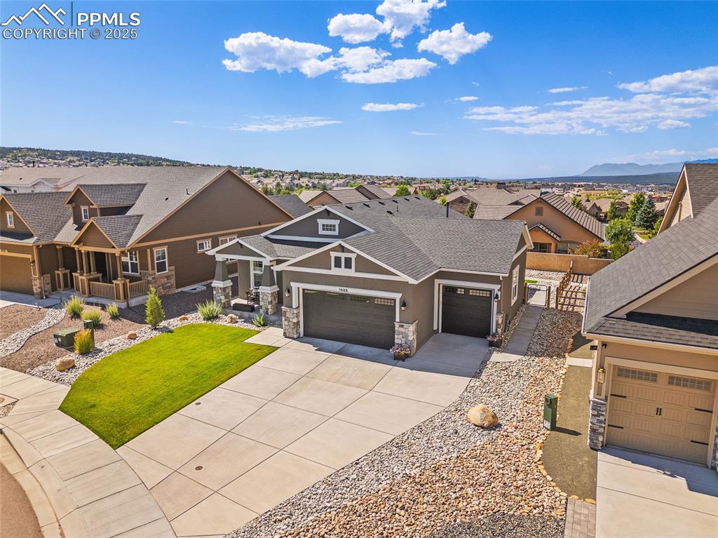 Image 25 of 41: View of front of house with stone siding, driveway, a residential view, stu