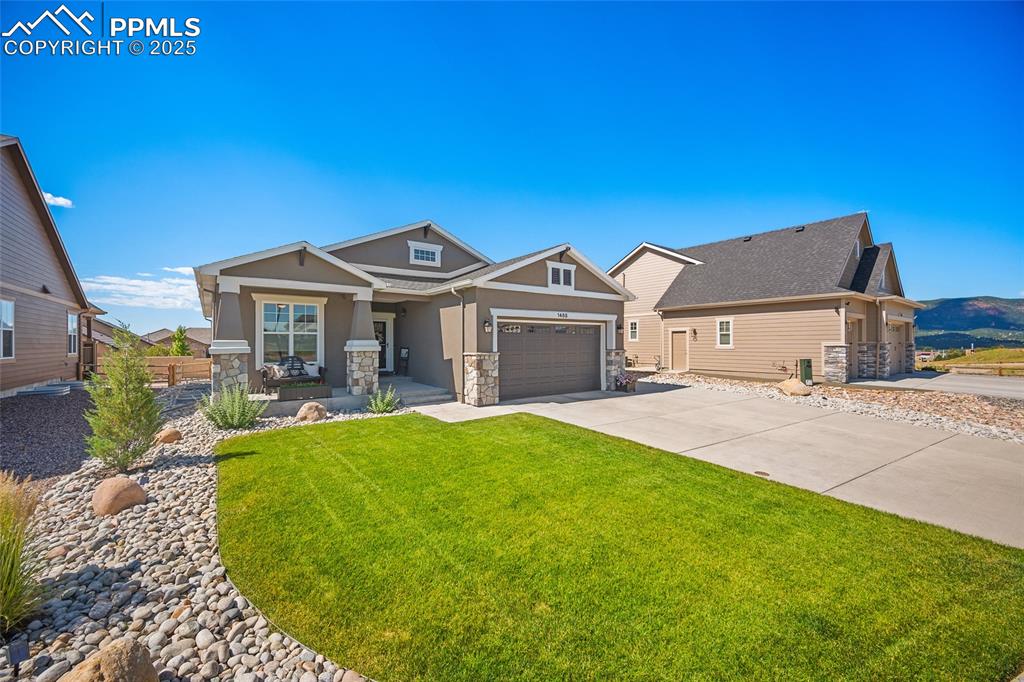 Image 3 of 41: Craftsman inspired home with covered porch, stucco siding, stone siding, a