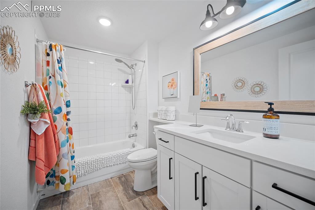 Image 39 of 41: Full bath featuring vanity, shower / tub combo with curtain, and wood finis