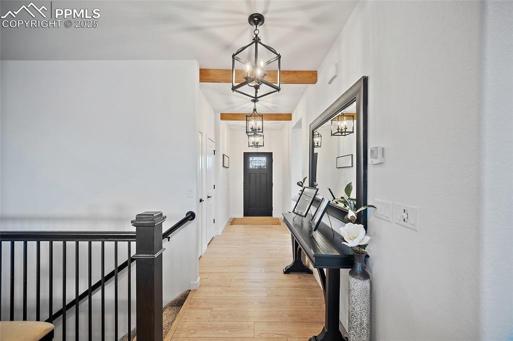 Image 40 of 41: Foyer entrance with light wood finished floors and a chandelier