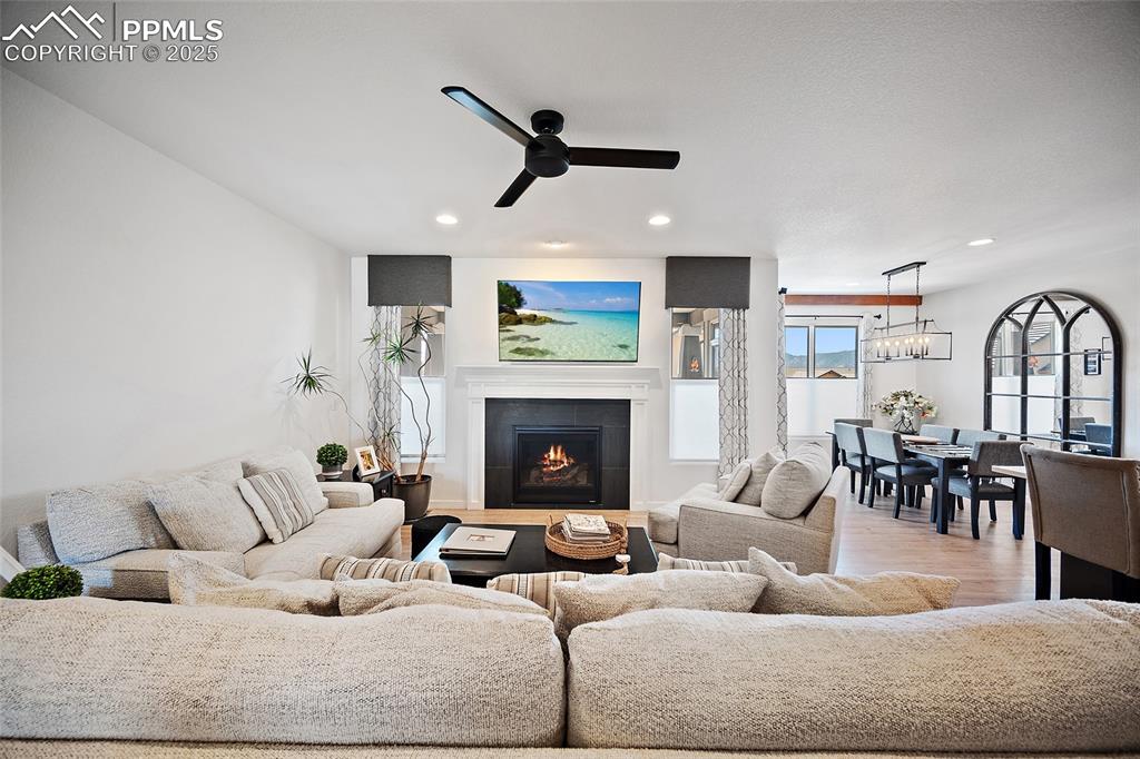 Image 5 of 41: Living room with recessed lighting, a tiled fireplace, a ceiling fan, a cha