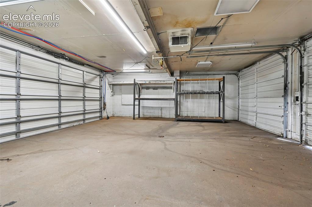Image 18 of 23: Concrete flooring and two roll-up garage doors