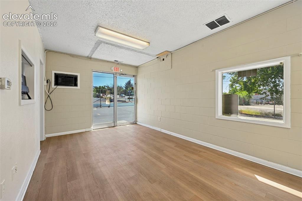 Image 9 of 23: Wood-finish flooring, full-light entry doors, and a built-in microwave
