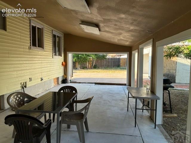 Image 18 of 19: Covered concrete patio with recessed lighting and a textured ceiling