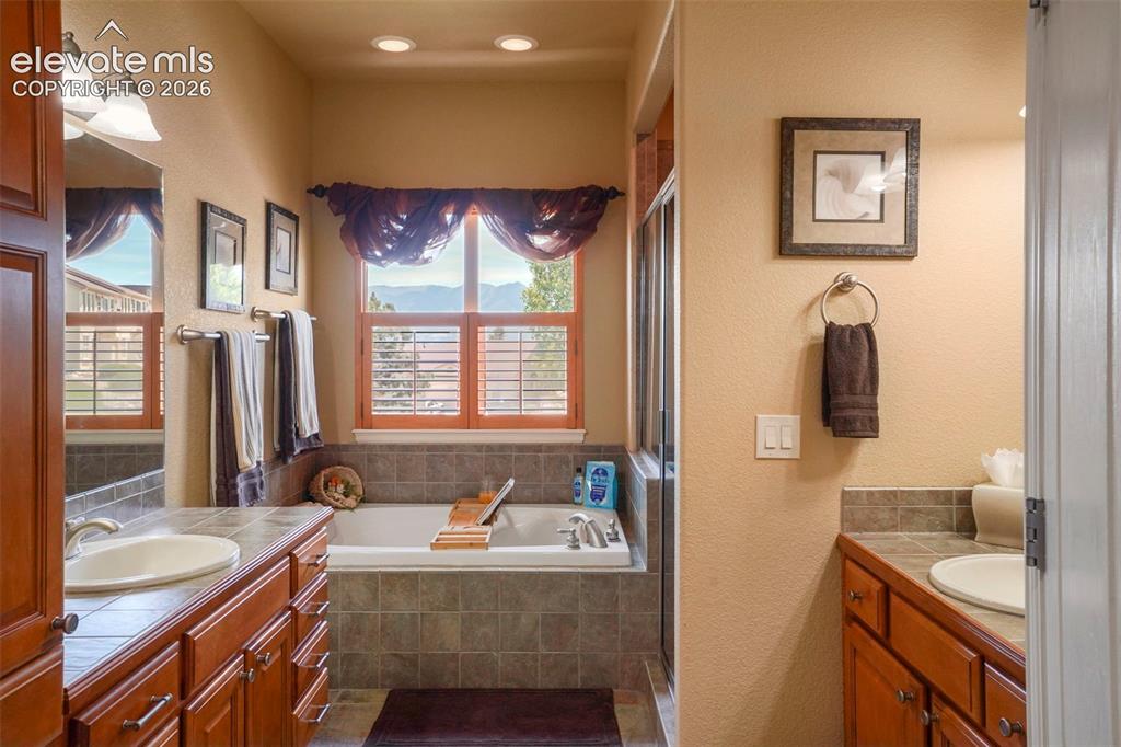 Image 17 of 36: Primary Bathroom with dual vanities, soaking tub and views!