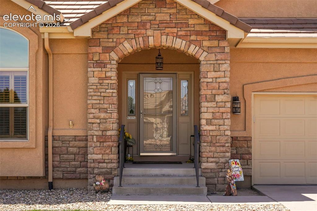 Image 2 of 36: Beautiful porch with stone accents and iron railings