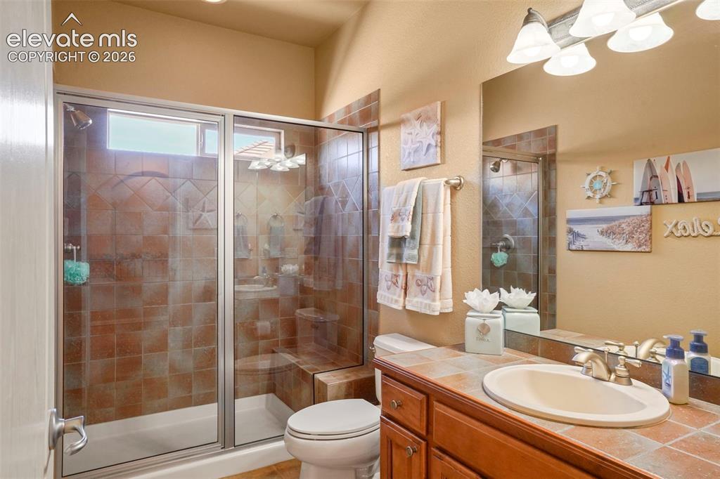 Image 22 of 36: Main level hall bath with shower bench